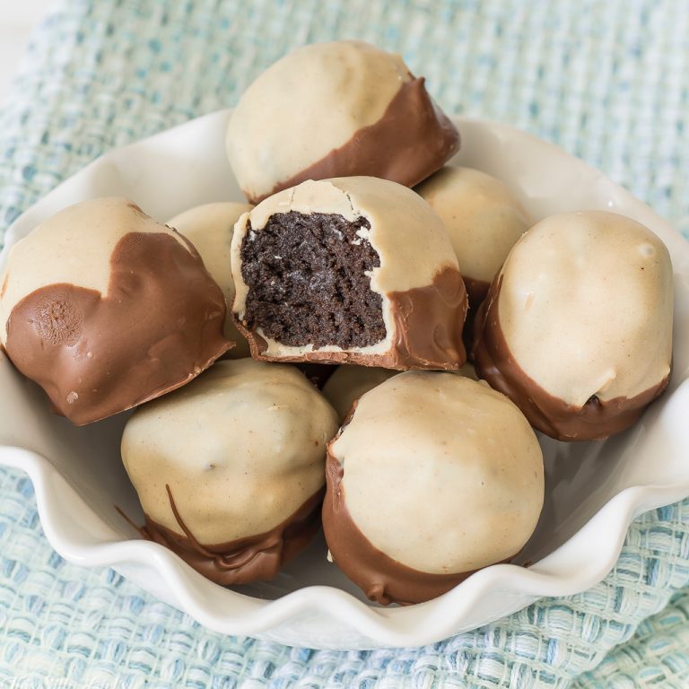 Square image of Buckeyes in bowl with bite taken out showing inside of one