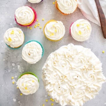 Best Fluffy Buttercream Frosting piped on cupcakes and a cake ready to serve.