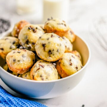 A bowl of glazed chocolate chip baked donut holes.