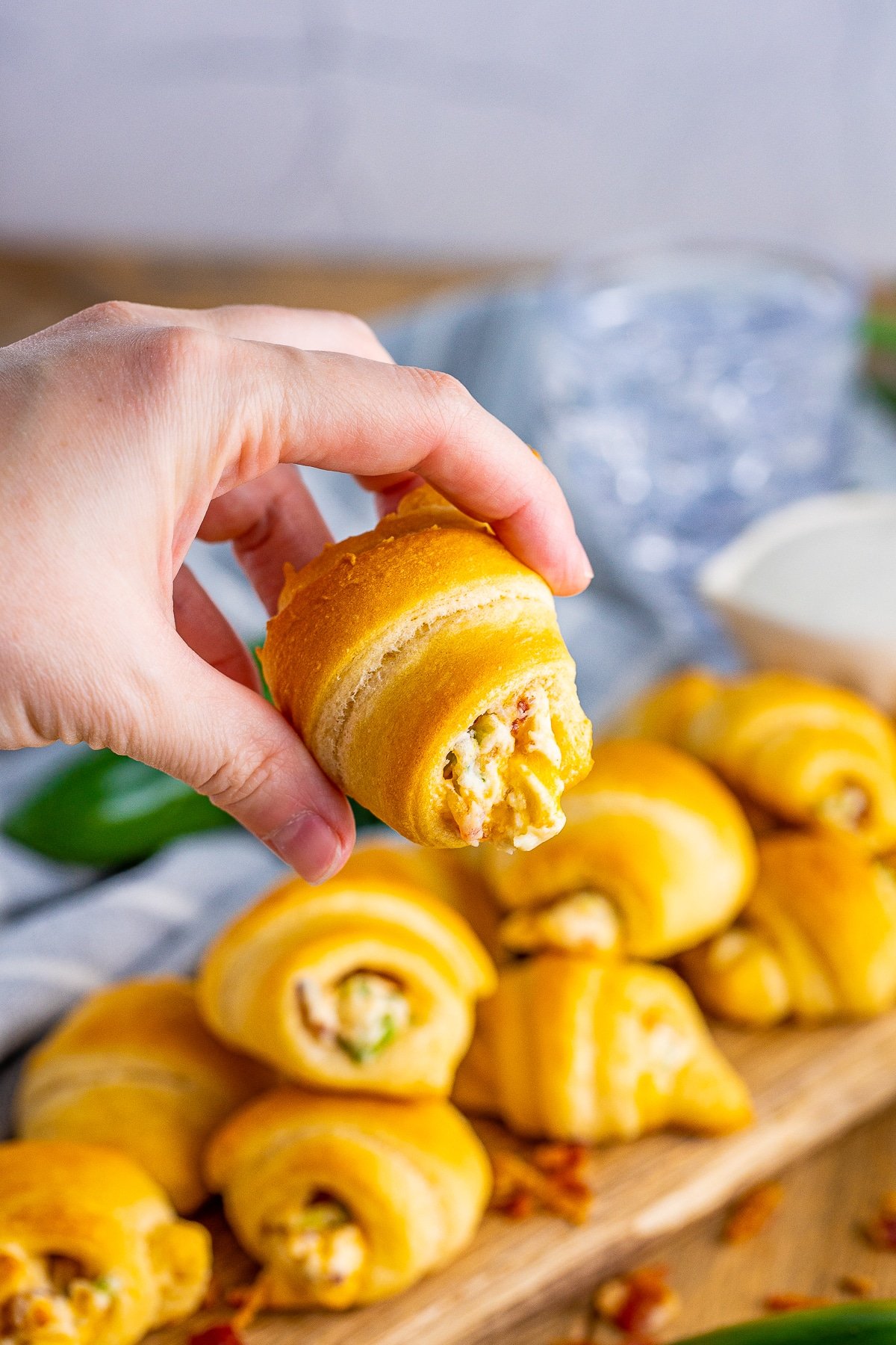 Hand holding up one of the Jalapeño Popper Crescent Rolls.