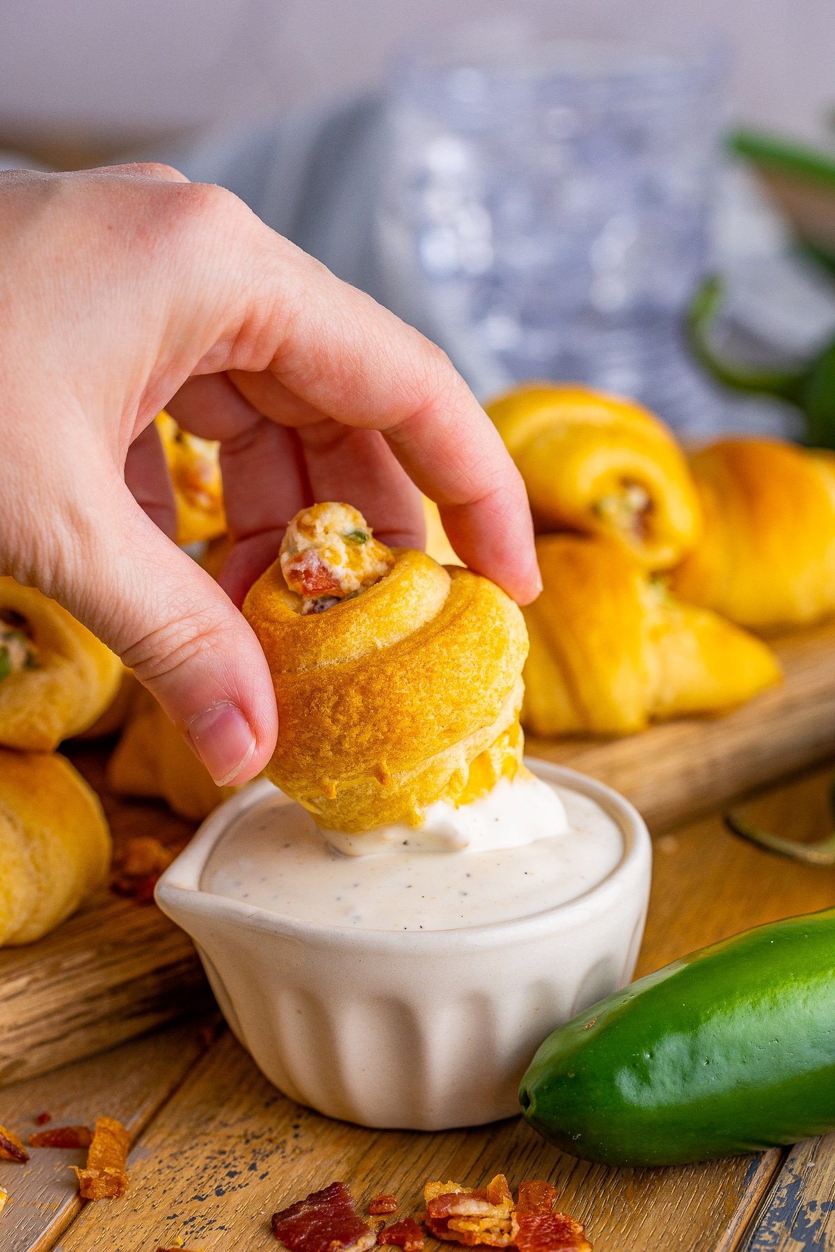 Hand dipping one of the Jalapeño Popper Crescent Rolls into ranch.