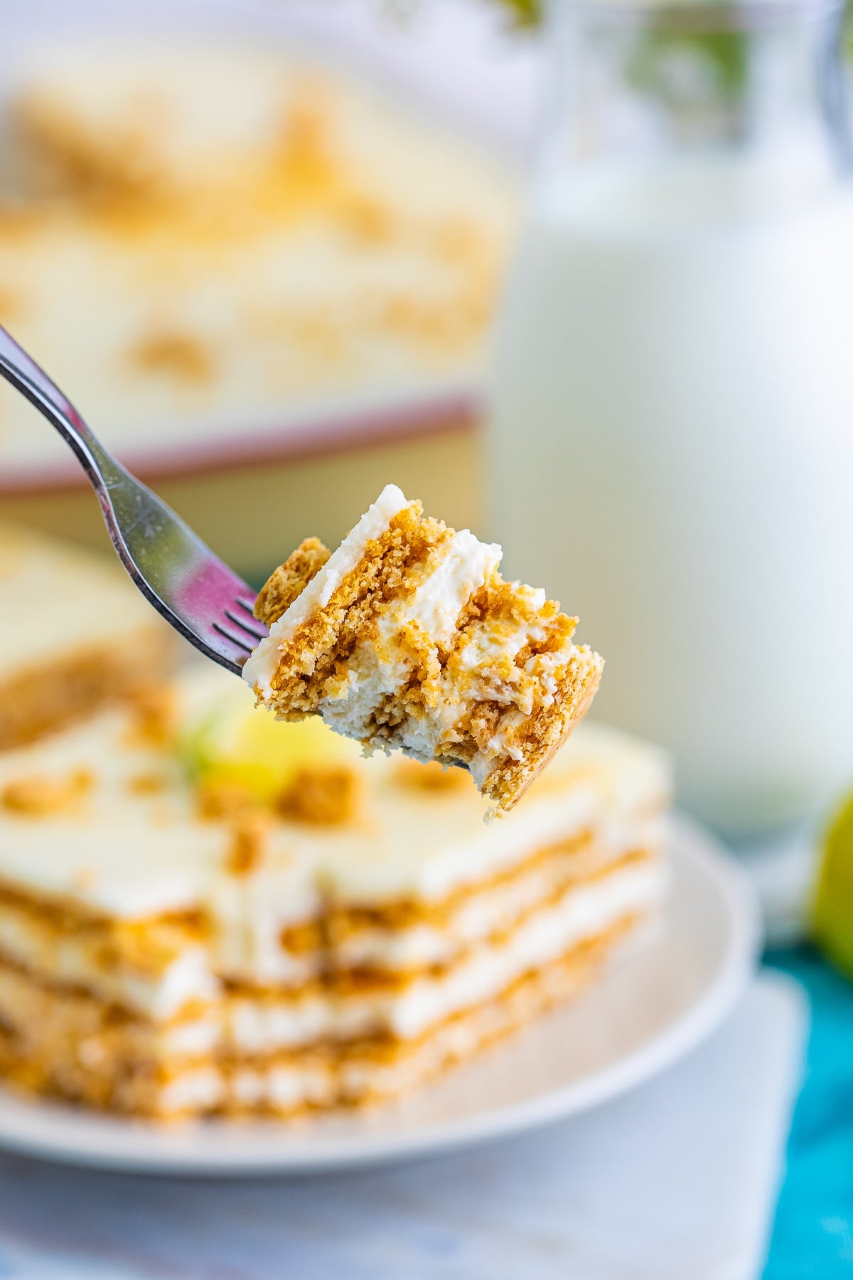 a fork holding up a bite of Eclair Cake in air