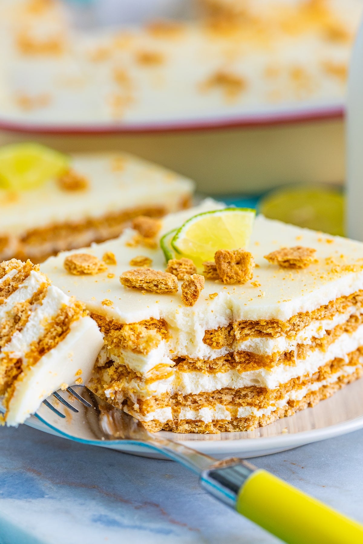 a slice of Eclair Cake with a bite taken out on a white plate