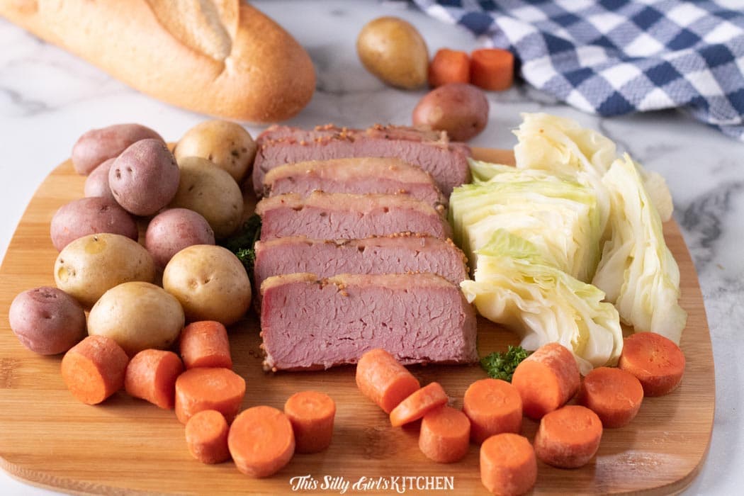Close up of sliced corned beef and vegetables on cutting board 