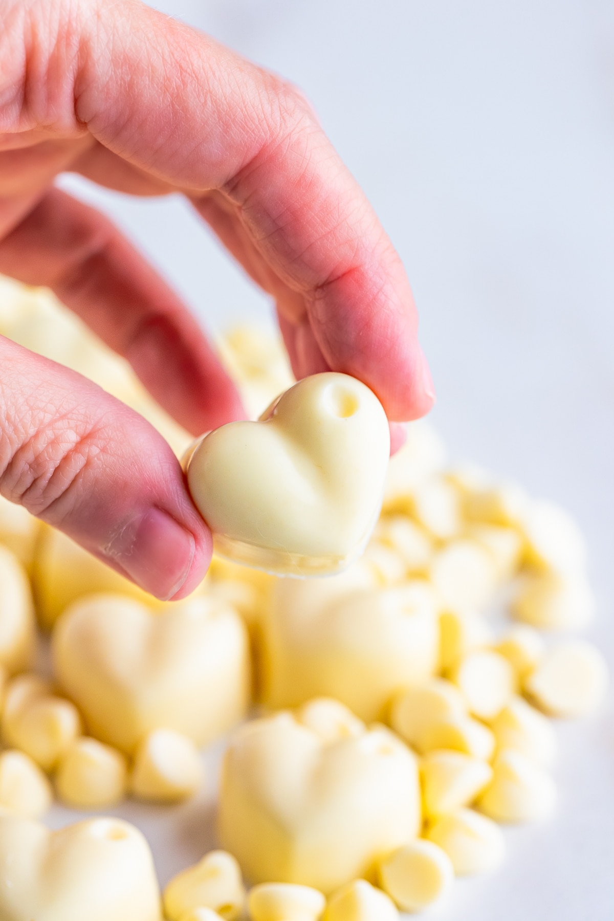 a hand holding up White Chocolate Truffles in air