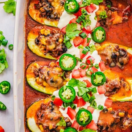 Finished Enchilada Stuffed Zucchini in pan with toppings.
