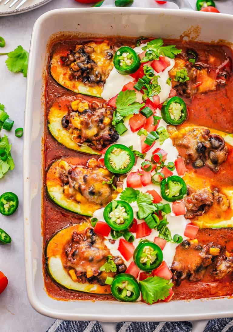 Finished Enchilada Stuffed Zucchini in pan with toppings.