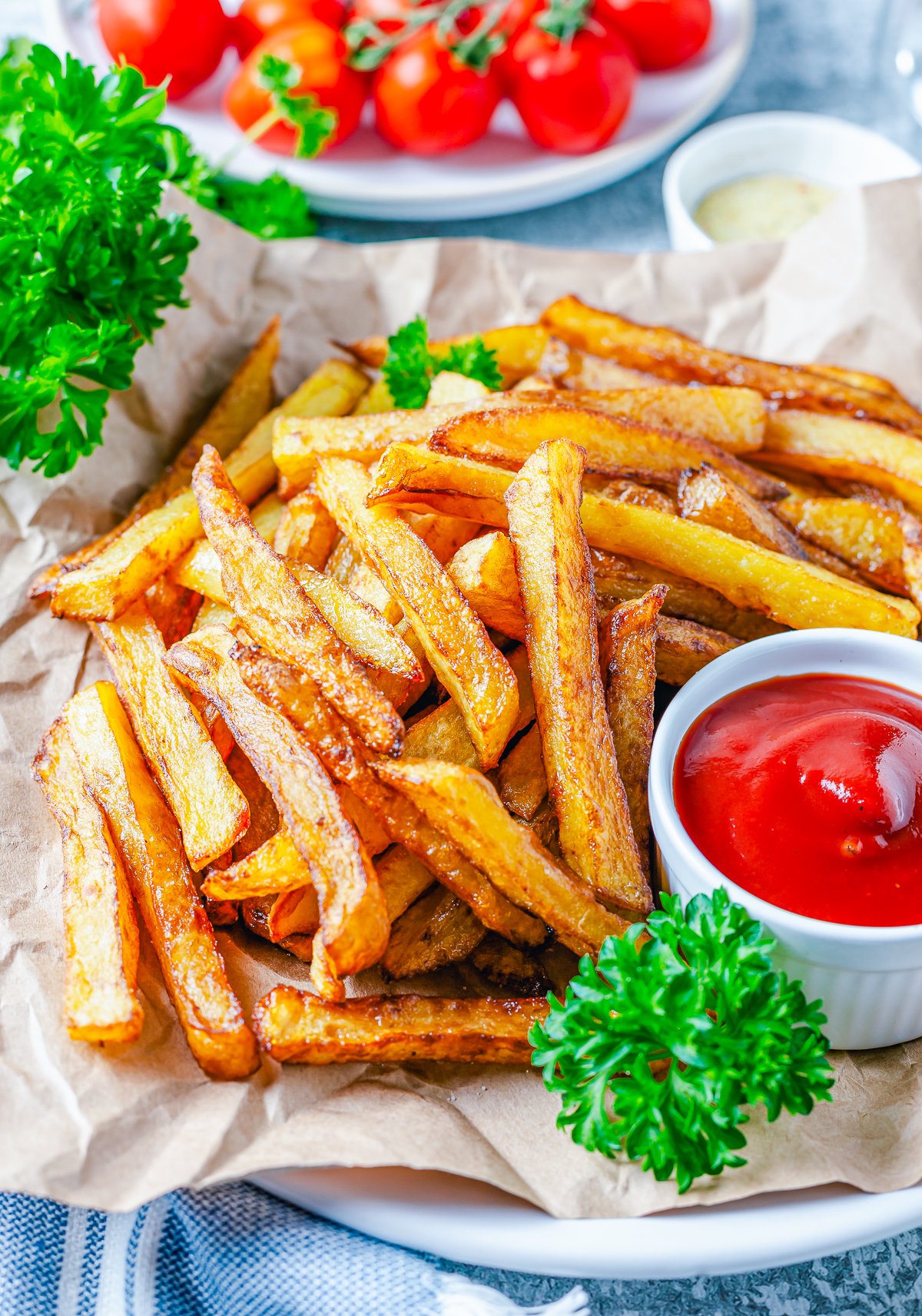 Side view of plated Homemade French Fries with ketchup and parsley.