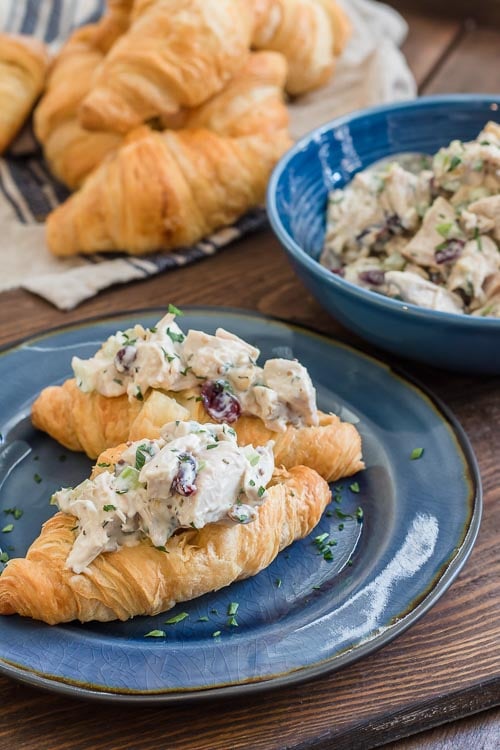 Creamy cranberry chicken salad with walnuts and cranberries served on a croissant.