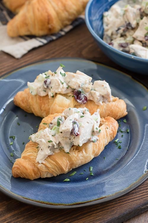 Cranberry chicken salad piled onto a flaky croissant with walnuts and cranberries.