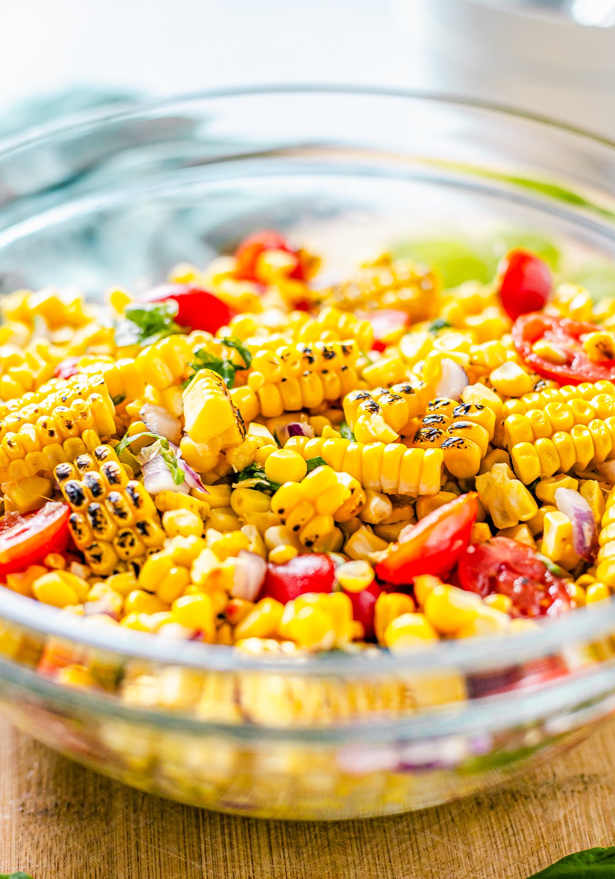 Side view of bowl of Corn and Tomato Salad showing charred corn