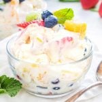 Square image of Tropical Cheesecake Salad in bowl topped with fruit