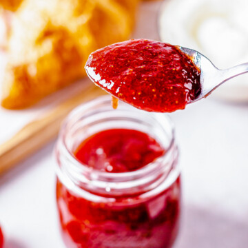 Spoon holding up some of the butter out of the jar.