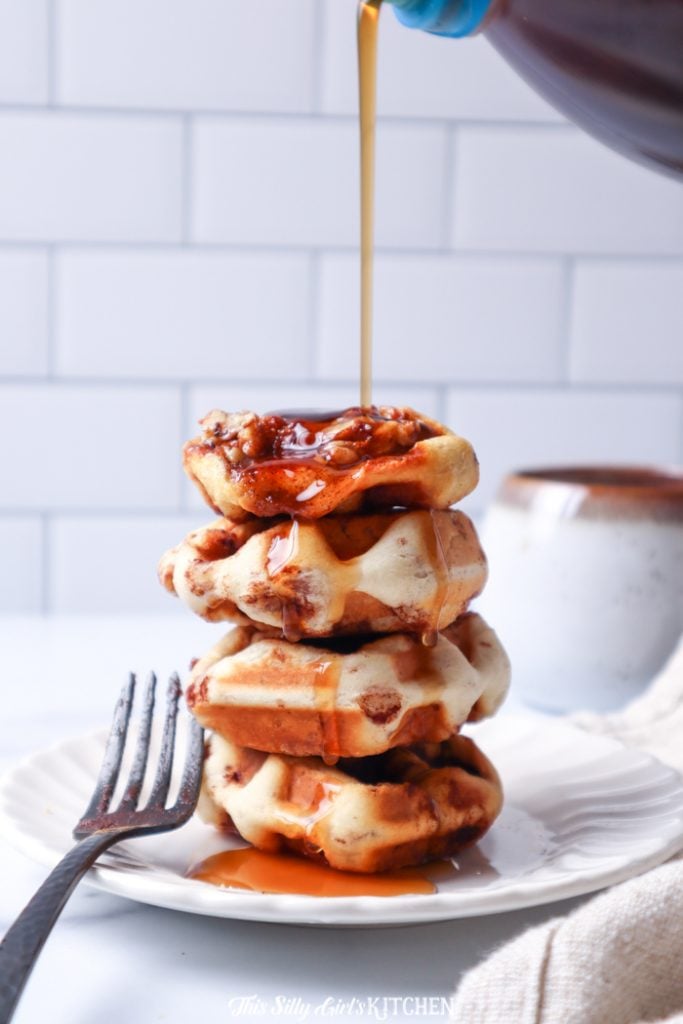 Syrup being drizzled off stacked Cinnamon Roll Waffles
