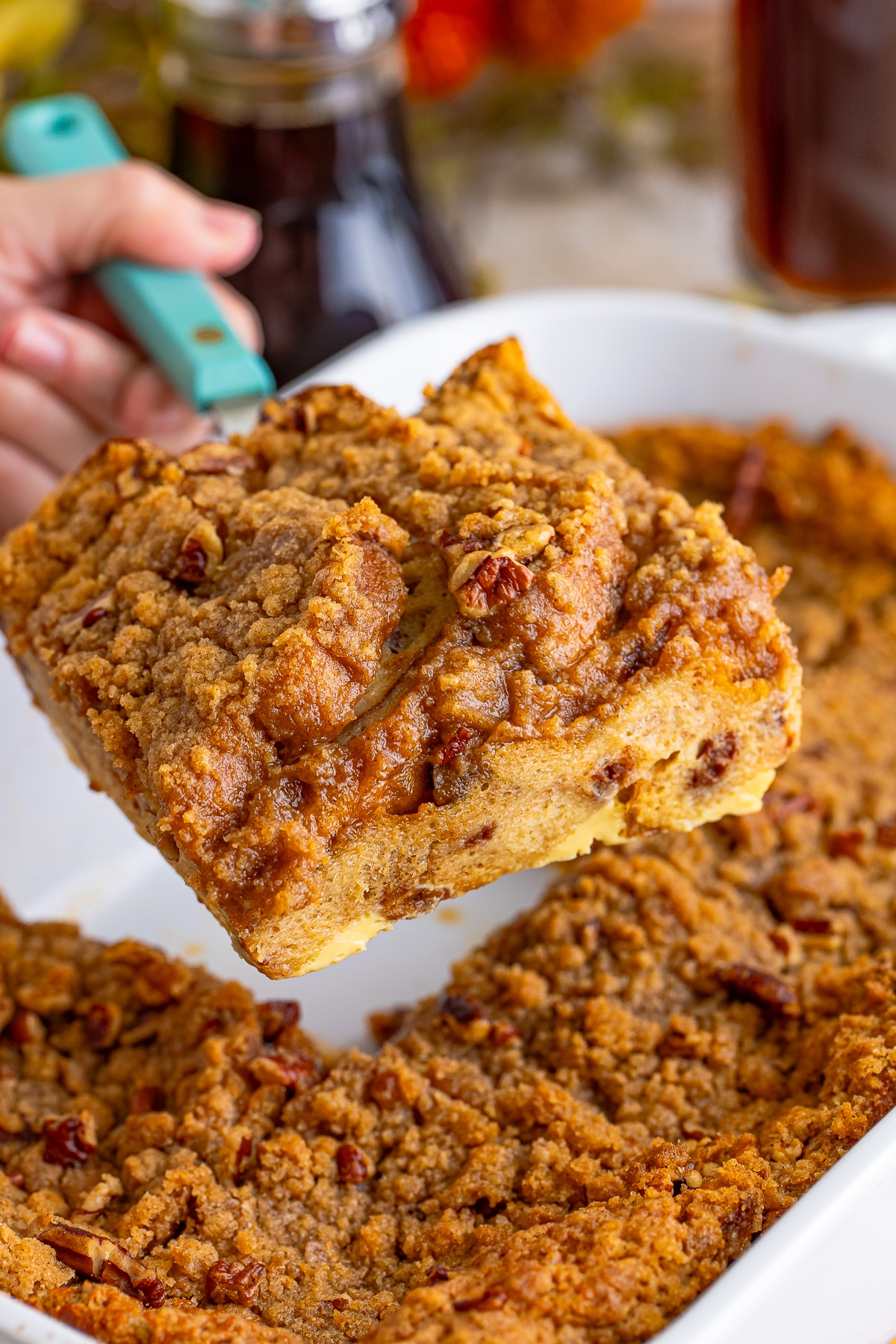 a piece of Overnight French Toast being held in the air with a spatula