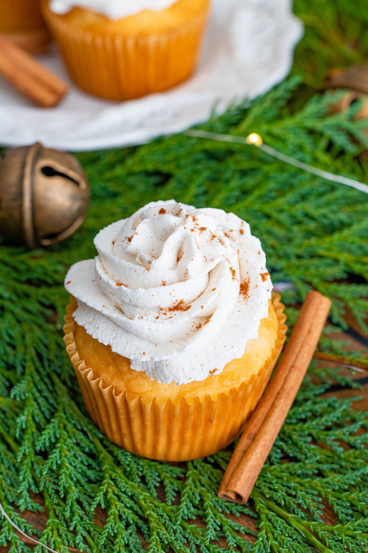 Overhead of eggnog cupcakes with cinnamon stick next to it