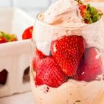 A glass of Stabilized Chocolate Whipped Cream layered with fresh strawberries.