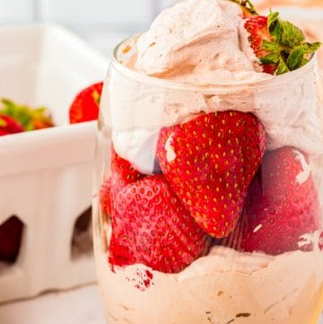 A glass of Stabilized Chocolate Whipped Cream layered with fresh strawberries.