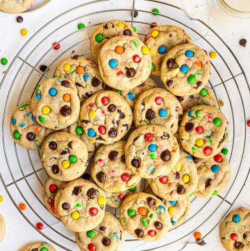 M&M Chocolate Chip Peanut Butter Cookies stacked on wire rack with cookies surrounding it