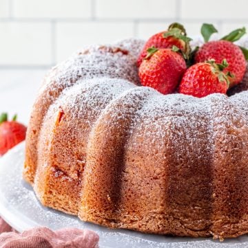 Finished Bundt Cake topped with powdered sugar and strawberries
