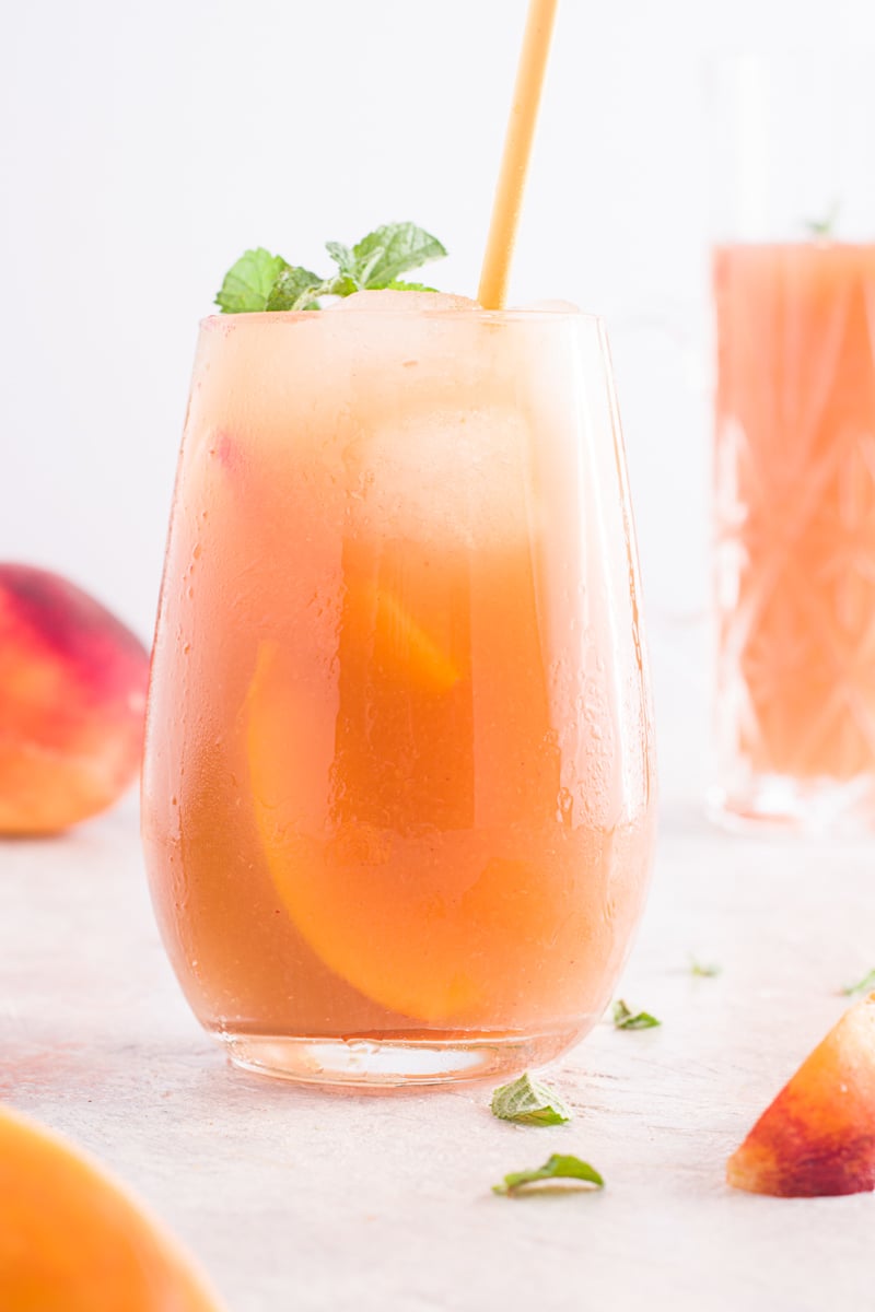 Peach Arnold Palmer in glass with straw