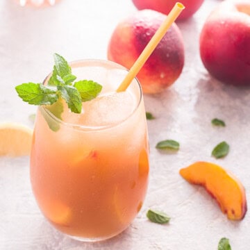 Close up of drink in glass with straw and peaches