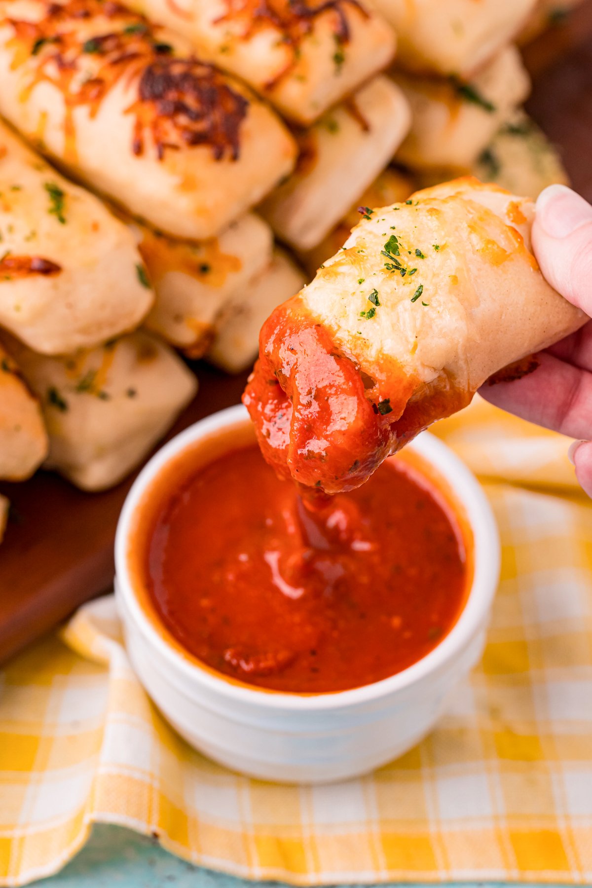Breadstick being dipping into sauce