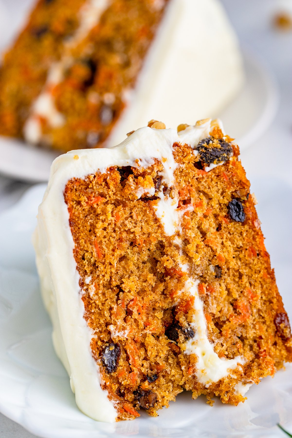 Close up of a slice of Layered Carrot Cake on white plate