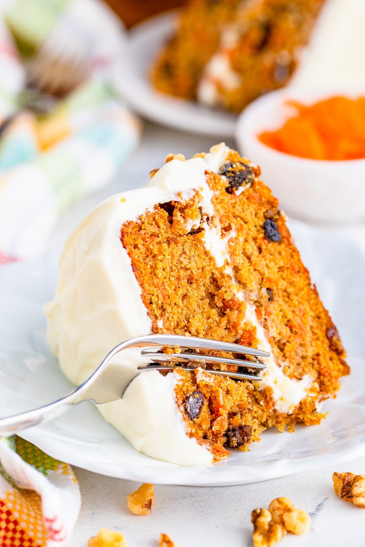 Fork cutting into slice of Layered Carrot Cake