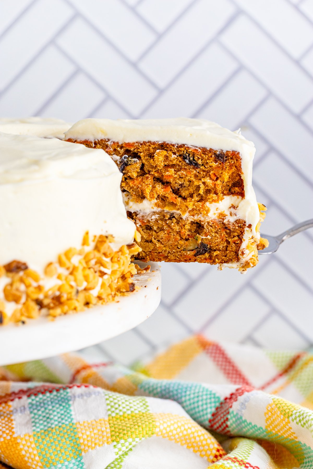 Cake server pulling out slice of Carrot Cake