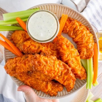 Plate full of Air Fryer Buffalo Chicken Tenders being held up