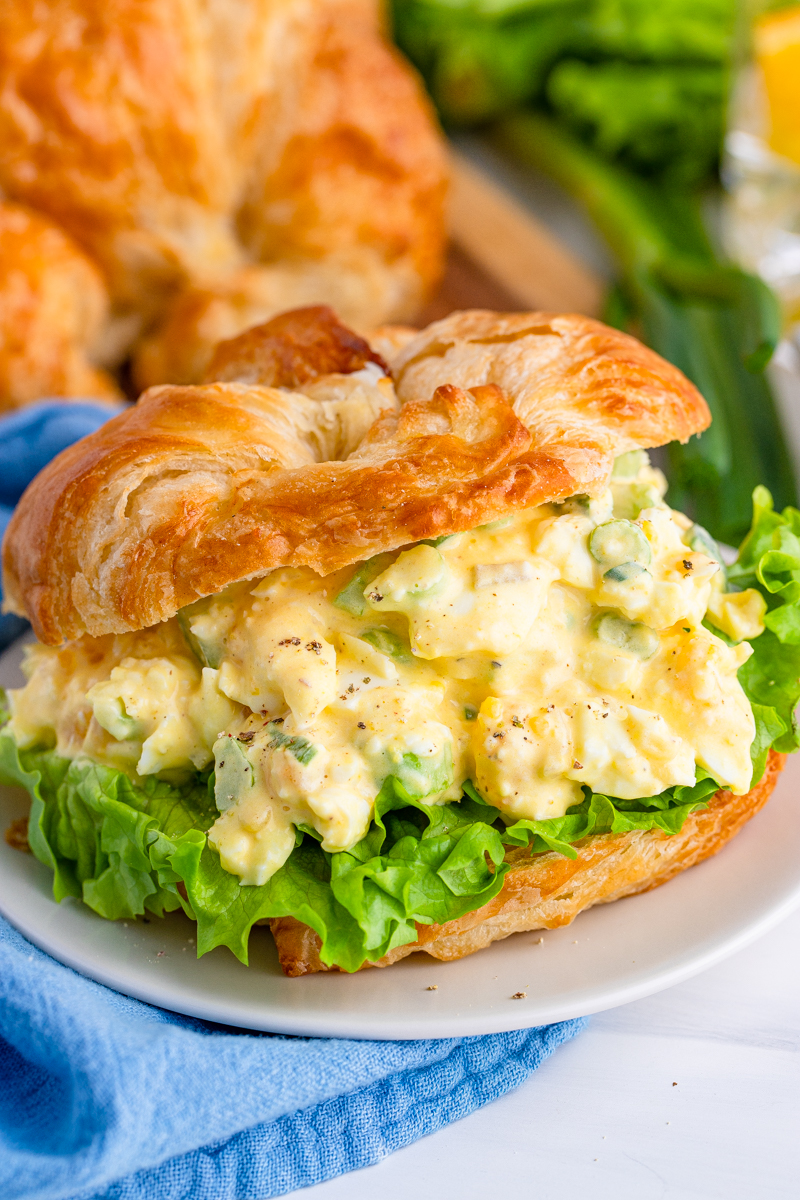 Egg Salad Sandwich Recipe in a croissant with lettuce on plate