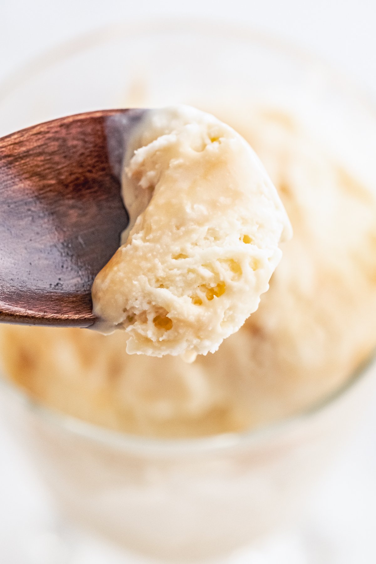 Spoon holding up a scoop of Caramel Ice Cream from glass