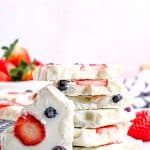 A stack of frozen Yogurt Bark pieces studded with strawberry slices and blueberries.