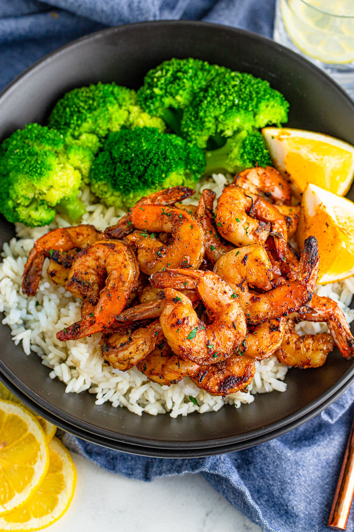 Shrimp overhead photo on black plate with rice and broccoili