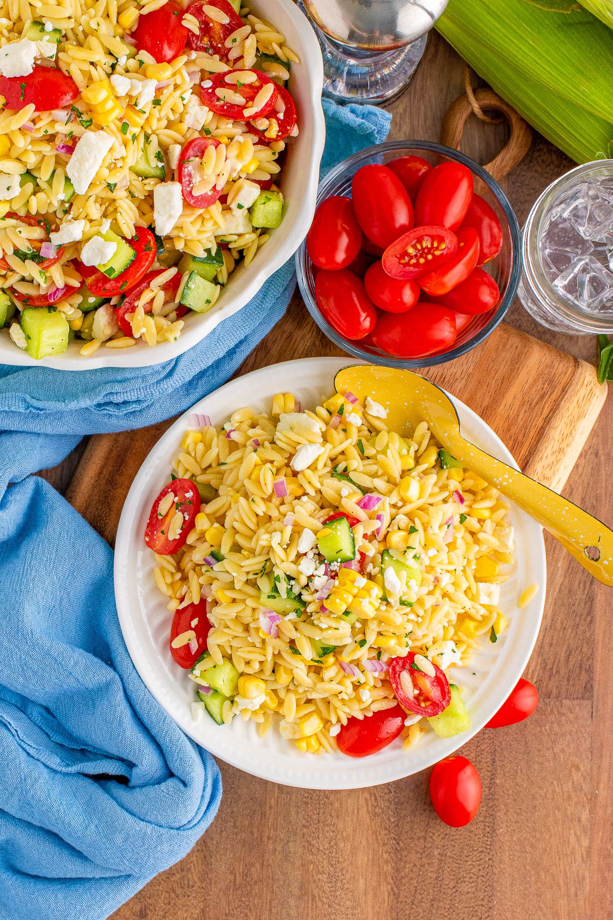Overhead of the Orzo Pasta Salad on white plate with spoon and ingredients