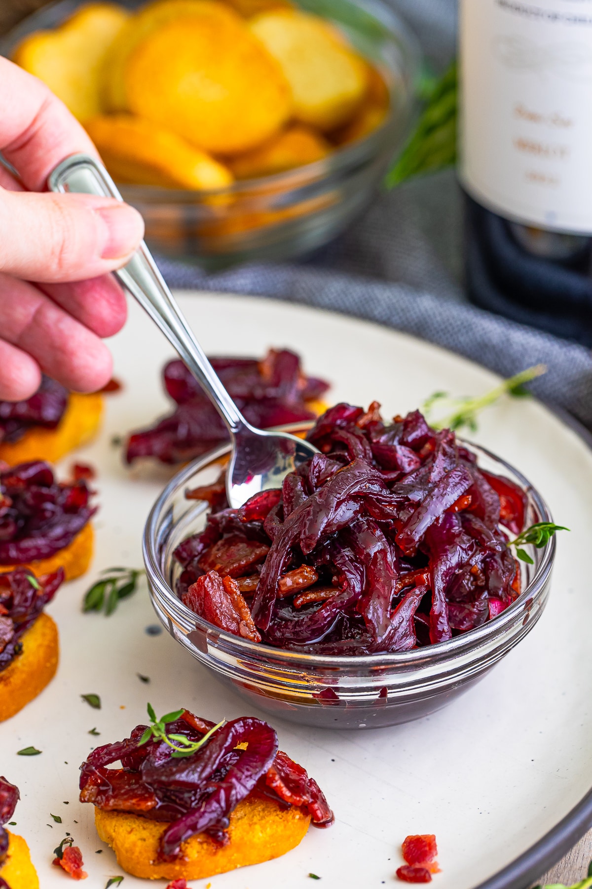 a spoon in a clear bowl scooping out a portion of Onion Marmalade
