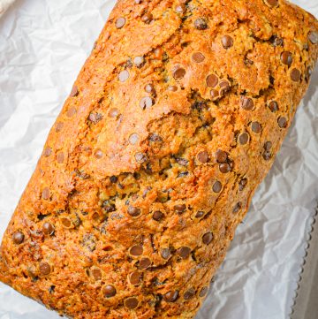Finished loaf of bread out of pan on parchment paper