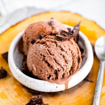A bowl of rich no churn chocolate ice cream topped with chocolate chunks.