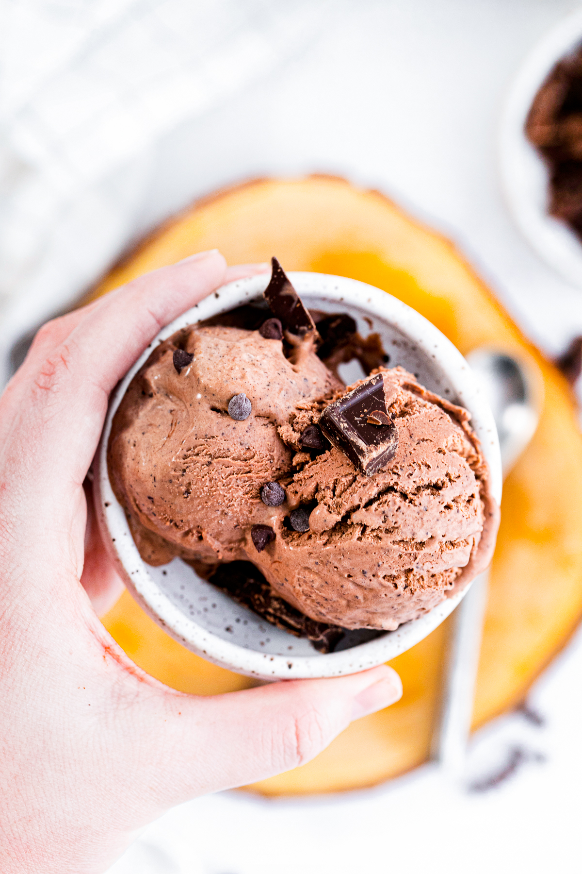 Overhead of hand holding bowl with Chocolate Ice Cream Recipe in it