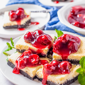 Stacked Cherry Cheesecake bars on white plate.
