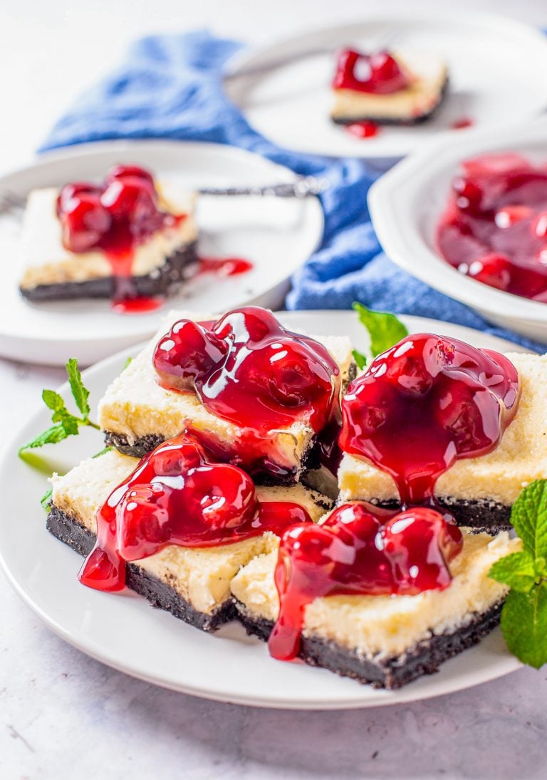 Stacked Cherry Cheesecake bars on white plate.
