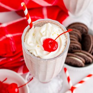 Overhead of milkshake showing whipped cream and cherry square image
