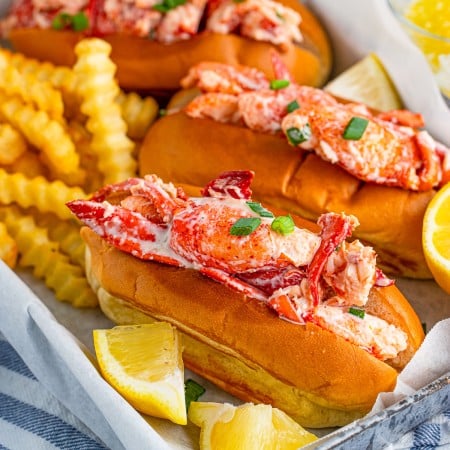 Square image of Lobster Rolls ion tray with French fries and lemon wedges
