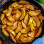 A cast iron skillet of buttery cinnamon fried apples.
