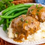 Two Salisbury Steaks on potatoes with beans square image.
