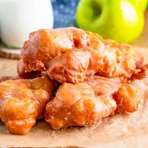 Square image of finished Apple Fritters stacked on top of one another.