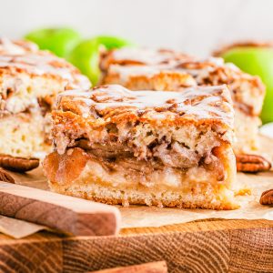 Close up square image of Apple Pie Bars cut on wooden board.