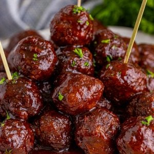 Square image of meatballs stacked with toothpicks.