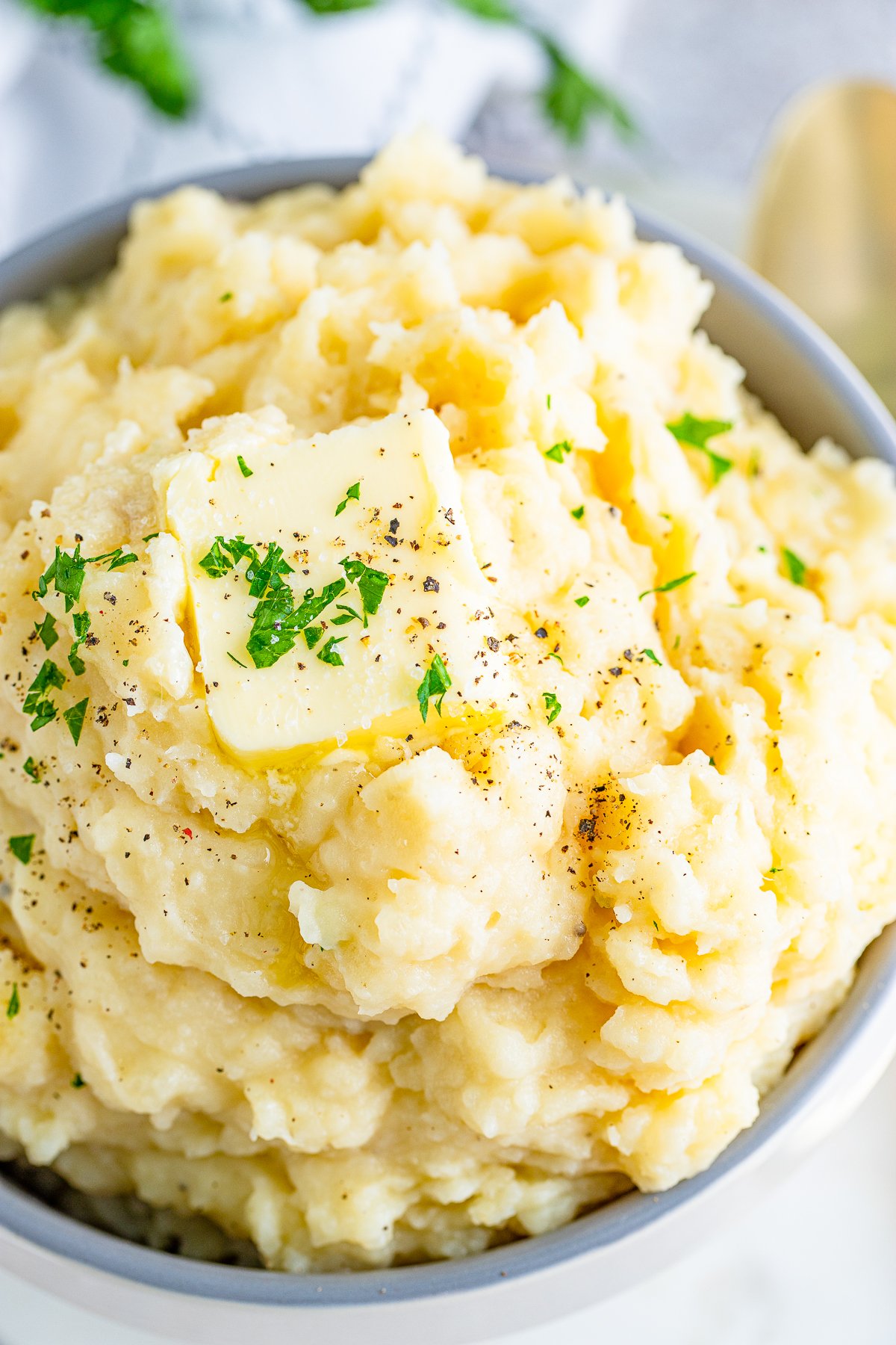 Overhead photo of butter and parsley garnished Slow Cooker Mashed Potatoes.